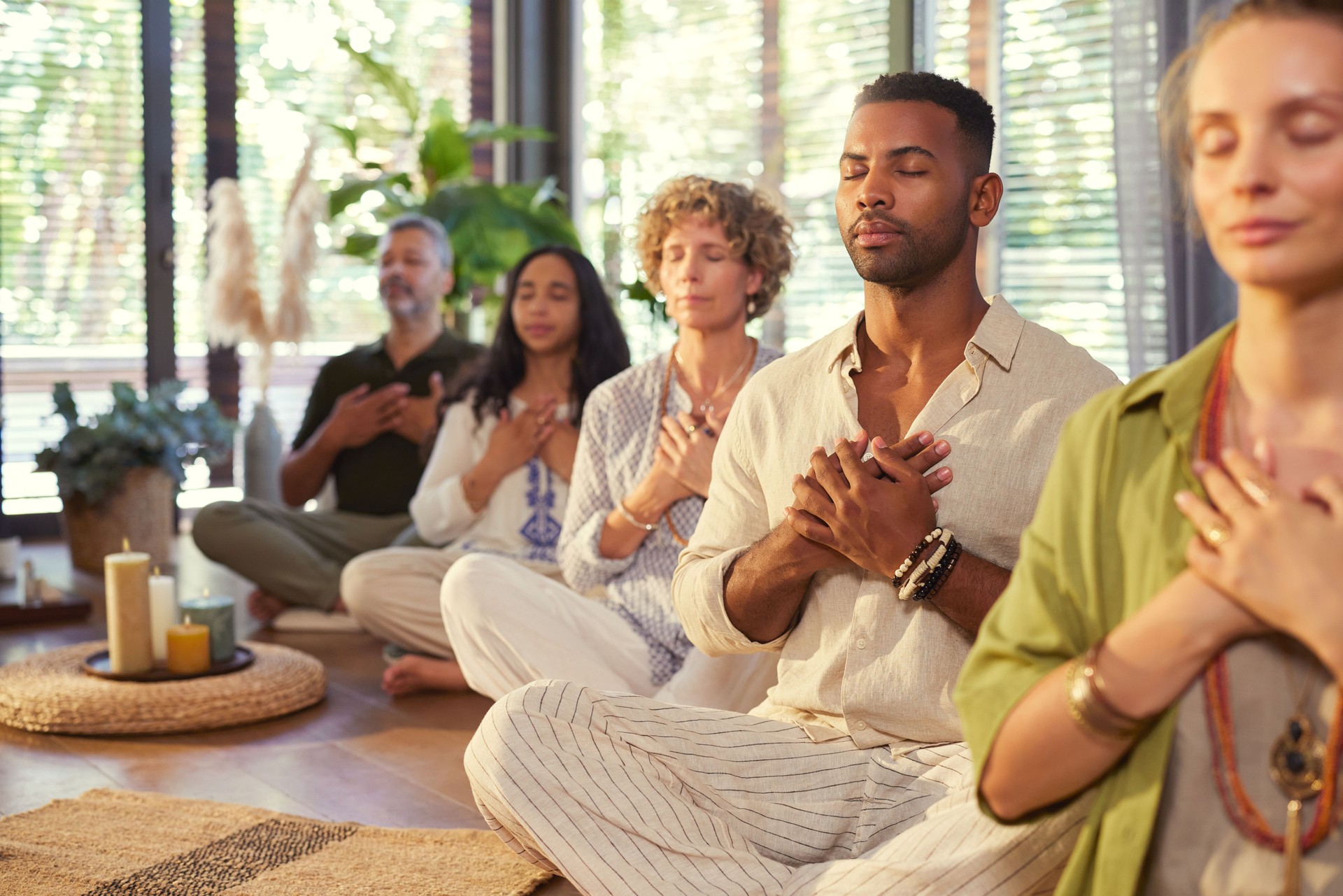 Multiethnic group of people practicing meditation with hands on heart